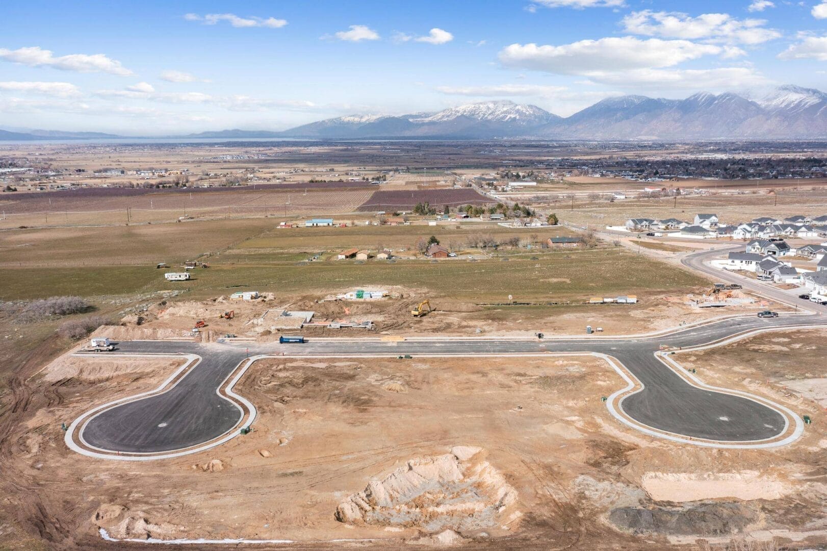 An aerial view of a construction site with mountains in the background overlooking Southern Utah Valley.