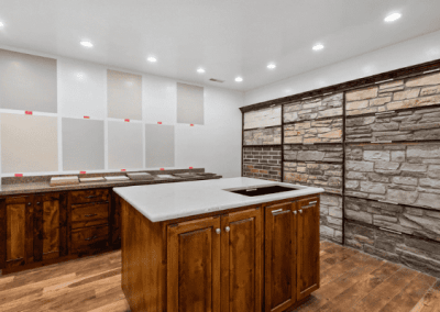A custom kitchen with wood cabinets and a stone wall, designed by Riding Homes in Southern Utah Valley.