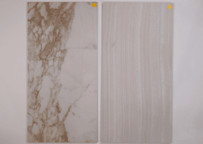 Two marble tiles with a yellow tag on them, suitable for custom home building projects in Southern Utah Valley.