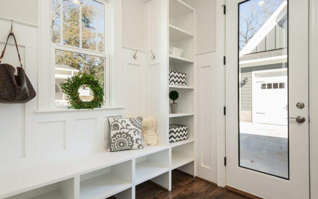 A Southern Utah Valley entryway with a white bench and bookshelves crafted by Riding Homes, a renowned custom home builder.