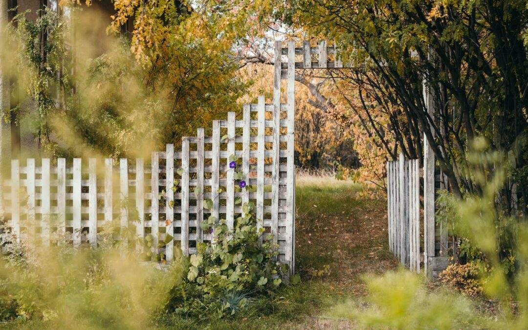 A white picket fence, expertly crafted by Riding Homes, nestled in the middle of a beautiful field in Southern Utah Valley.