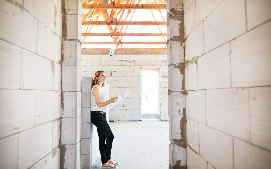 A woman is standing in a room that is under construction in Southern Utah Valley.