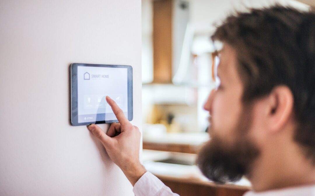 A man with a beard is using a tablet to control the heating in his Southern Utah Valley home.